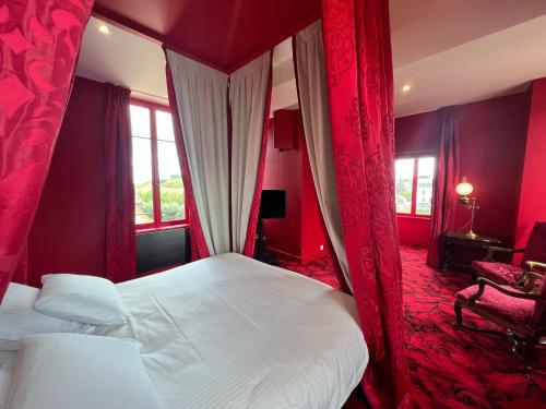 - une chambre avec un lit à baldaquin et des murs rouges dans l'établissement La Maison à Pan De Bois Chambre Napoléon III, à Vierzon