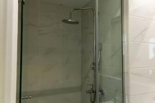 a shower with a glass door with a light on it at Avery 2 Studio @Embassy Gardens in Accra