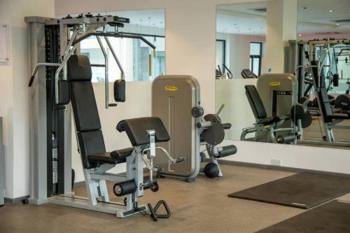 a gym with several tread machines and mirrors at Avery 2 Studio @Embassy Gardens in Accra