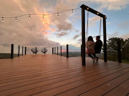 Ein Paar sitzt auf einem Deck und sieht den Sonnenuntergang. in der Unterkunft Amalú Monteverde in Monteverde Costa Rica