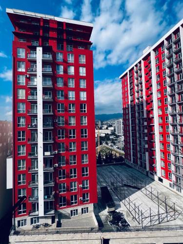 a red building in front of two tall buildings at Kakha in Tbilisi City