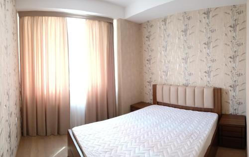 a bedroom with a white bed and a window at Kakha in Tbilisi City