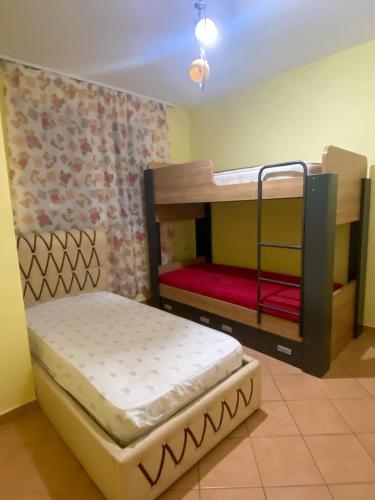 Habitación con 2 literas y 1 cama. en YourHome Vilat Gjermane, en Tirana