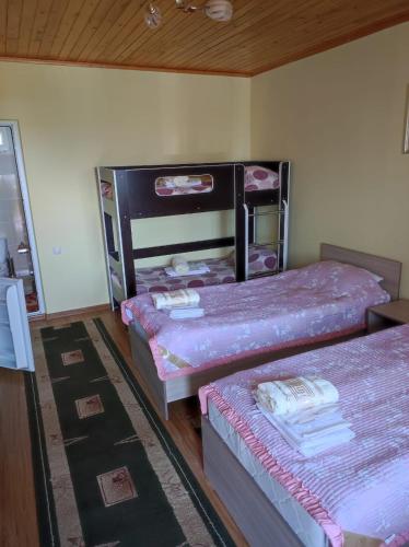 2 camas en una habitación con sábanas rosas en Уютный Дворик Чолпон-Ата, en Cholpon-Ata