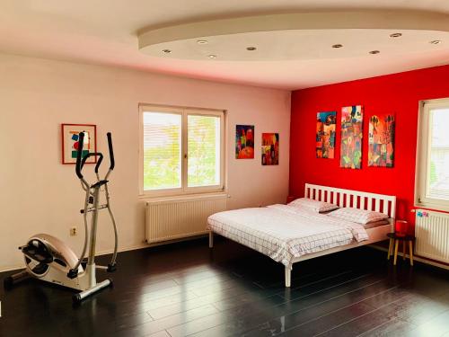 um quarto com paredes vermelhas, uma cama e uma passadeira. em Apartman STUDIO Sch Sch Sch em Saraievo