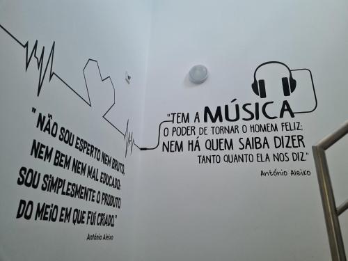 a sign on the wall of a bathroom with a musica sign on it at Hostel Supremo in Armação de Pêra