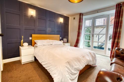 a bedroom with a large bed and a window at Pass the Keys 2 Bed Flat in Old School House in Lincoln