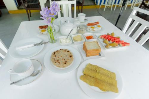 een witte tafel met borden voedsel erop bij Hotel Vacanza in Mirissa