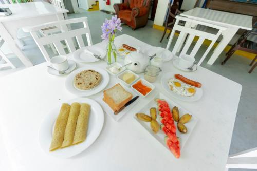 een witte tafel met borden voedsel erop bij Hotel Vacanza in Mirissa