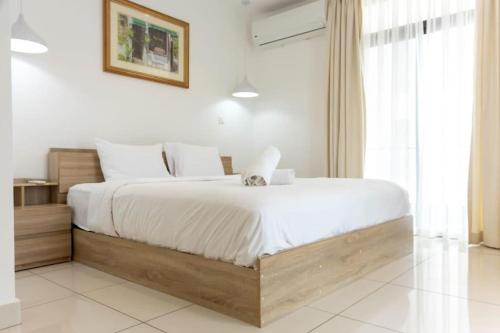 une chambre avec un grand lit avec des draps blancs dans l'établissement Best 1 Bedroom Plus Guest Toilet @Embassy Gardens, à Cantonments