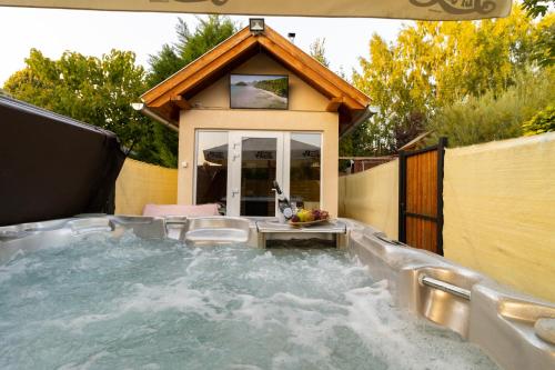 a hot tub in a backyard with a house at Szelidi Apartmanok in Dunapataj