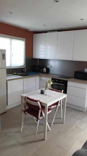 une cuisine avec une table blanche et une table et des chaises dans l'établissement CASA BELLA, à Pierrefeu-du-Var