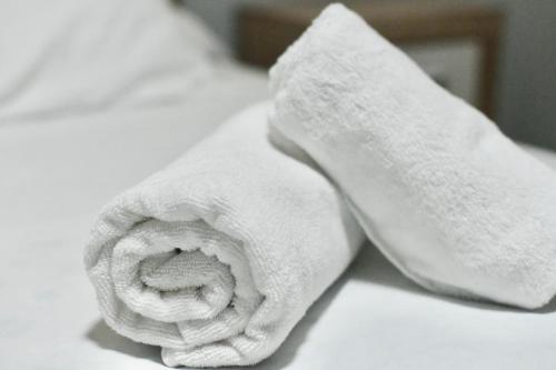 - une serviette blanche assise au-dessus du lit dans l'établissement Apartamento San Juan de la Cruz, à Gijón