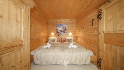 a bedroom with a bed in a wooden cabin at Chalet Stockerdörfl Apartment 68m2 by ONE-VILLAS in Kitzbühel