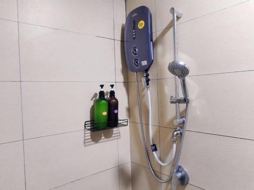 a shower with a blow dryer and two bottles on a wall at PWTC Titiwangsa HKL near MRT family in Kuala Lumpur