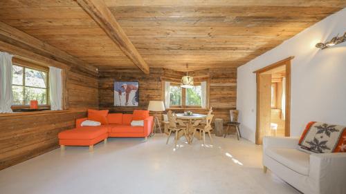 a living room with wooden ceilings and a table and chairs at Apartment Stockerdörfl Natur & Ruhe in Kitzbühel in Kitzbühel