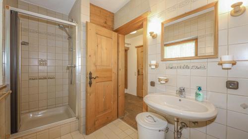 La salle de bains est pourvue d'un lavabo, de toilettes et d'une douche. dans l'établissement Chalet Stockerdörfl Apartment 68m2 by ONE-VILLAS, à Kitzbühel