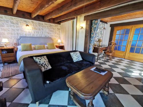 uma sala de estar com uma cama, um sofá e uma mesa em Le gîte du Brouage em Chauny