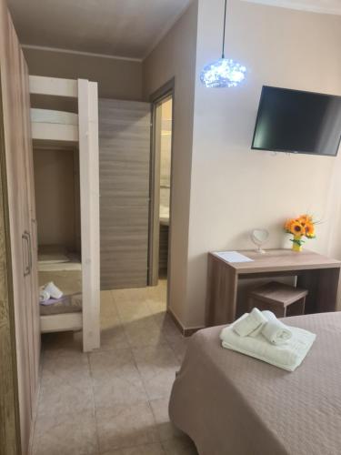 a bedroom with a bed and a desk and a television at Agriturismo Cara Terra Lucana in Chiaromonte