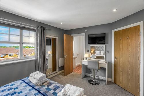 a bedroom with a bed and a desk and a window at Sandy Lane Apartment in Skelmersdale