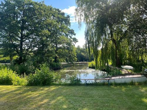 a pond in a park with trees and grass at Einmal Auftanken bitte... Kiel...direkt am See.. in Molfsee
