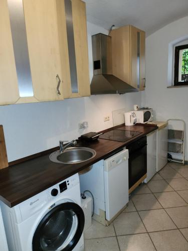 a kitchen with a sink and a washing machine at Halle, TOP -PREISE, große 79 qm SD FeWo, EG, wahlweise mit 1- 3 DZ, inklusiv TV Lounge, Küche, Bad WC Einfach und gut, Langzeitmieter VB Preise in Halle an der Saale