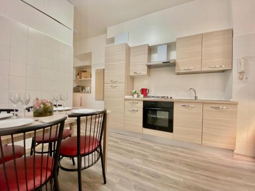 een keuken met een tafel, wat stoelen en een aanrecht bij Nido della Regina in Turijn