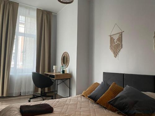 a bedroom with a bed and a desk and a chair at La Mia Casa Apartament Świdnica in Świdnica