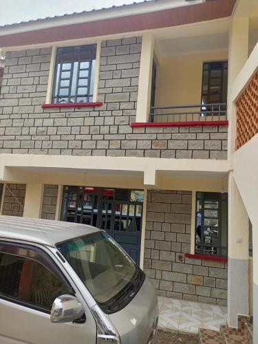 a house with a car parked in front of it at Kozi Luxury Apartment in Kisumu in Kisumu