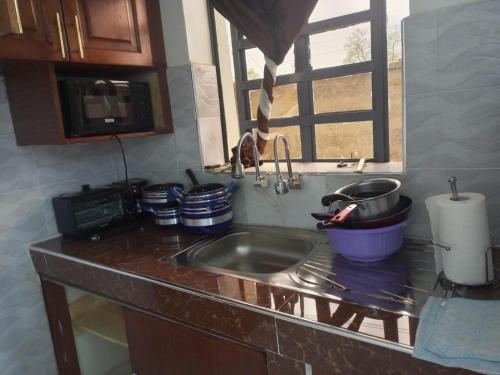 a kitchen counter with a sink and a window at Kozi Luxury Apartment in Kisumu in Kisumu