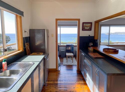 a kitchen with a view of the ocean at Elevated 3BR, ocean views, pool table, Pirates Bay in Eaglehawk Neck