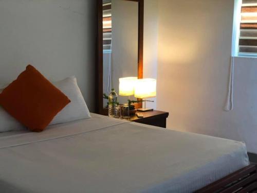 a bedroom with a bed with a mirror and a lamp at Sea Crest Beach Villa in Ambalangoda