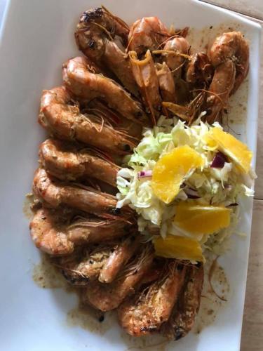 a plate of food with sausages and coleslaw at Sea Crest Beach Villa in Ambalangoda