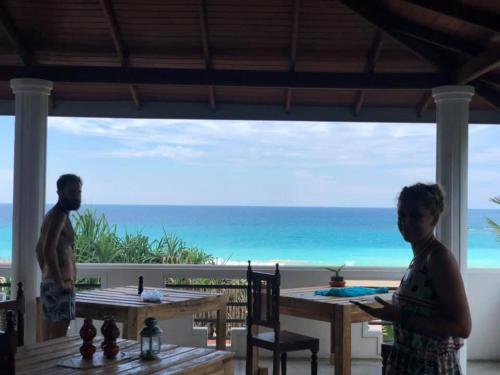 a man and a woman standing in front of the ocean at Sea Crest Beach Villa in Ambalangoda