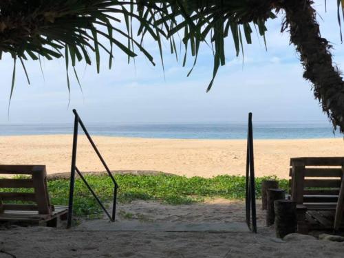 a beach with two chairs and a swing at Sea Crest Beach Villa in Ambalangoda