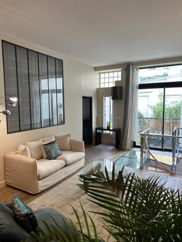 un salon avec un canapé et une table en verre dans l'établissement Canal Saint Martin apartments, à Paris