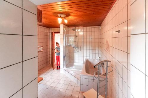 a woman standing in a bathroom with a sink at Ferienwohnung Obermühle in Alter Graben