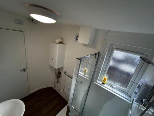 a bathroom with a toilet and a window in it at Spacious 5-Bedroom Urban Haven in Luton