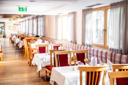 a row of tables in a restaurant with white tablecloths at Das Hopfgarten Familotel Tirol in Hopfgarten im Brixental