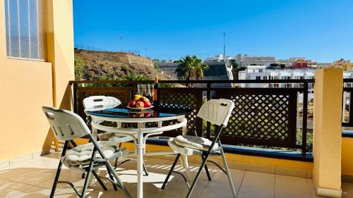a balcony with a table with a bowl of fruit on it at Sunset apart, large terrace, pool, Best location! in Puerto de Santiago