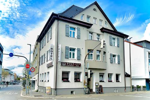 Hotel Post Sindelfingen في شيندلفينجن: مبنى ابيض على زاوية شارع