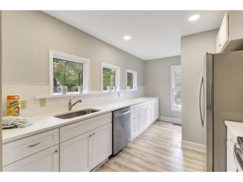 a kitchen with white cabinets and a stainless steel refrigerator at 1 Egret Street N Forest Beach in Hilton Head Island