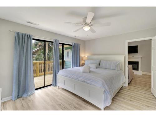 een witte slaapkamer met een bed en een plafondventilator bij 1 Egret Street N Forest Beach in Hilton Head Island