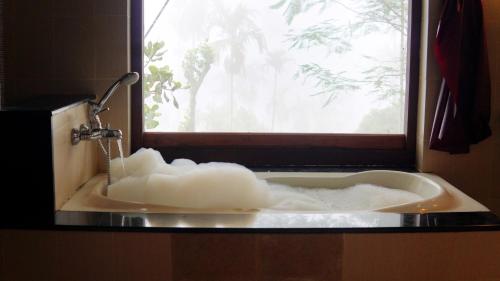 a bathroom sink with a large white object in it at Rain Clouds Wayanad Forest Retreat - The Best Couple Friendly Private Cottages with Bathtub in Wayanad