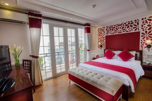 a bedroom with a large bed and a large window at La Beaute De Hanoi Hotel in Hanoi