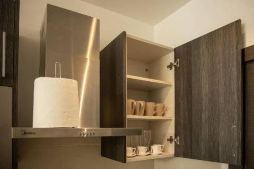 a kitchen with a shelf with cups and a towel at Cantonments Beautiful 2 Bedroom Apartment in Cantonments