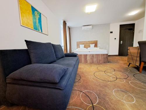 a living room with a couch and a bed at Wellness Hotel Vinnay in Vinné