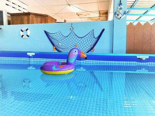 a swimming pool with a purple rubber duck in the water at Homestay Temerloh with private pool, Yhc Homestay in Temerloh