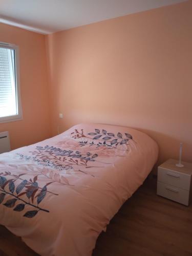 a bedroom with a bed with a comforter on it at Chez Nelly in Versaugues