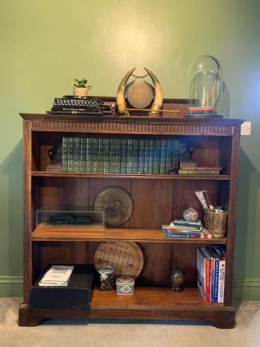 a book shelf filled with books and other items at Hidden gem in heart of Breckland in Watton